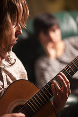 Image showing Young Musician Plays His Acoustic Guitar as Friend Listens