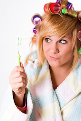 Image showing housewife with curlers and toothbrush