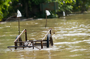 Image showing Handcart left at a flooded road