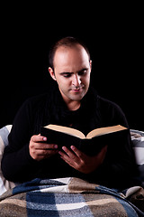 Image showing man lying on the couch reading a book