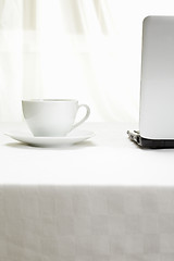 Image showing Coffee and laptop on white tablecloth