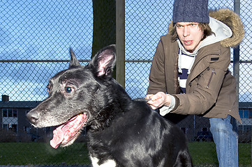 Image showing Vicious dog leaping away from his owner