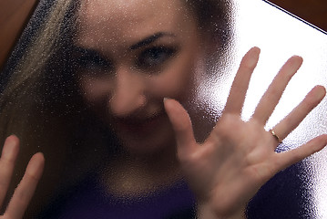 Image showing Girl behind the glass  door