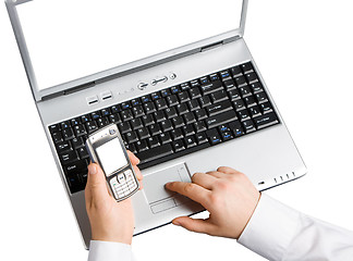 Image showing Using a laptop and a mobile phone