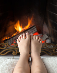 Image showing Children's feet are heated in the fireplace