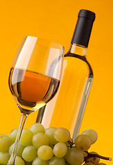 Image showing Bottom view of a glass of white wine bottle and grapes 