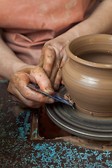 Image showing Potter creates a pitcher on a pottery wheel