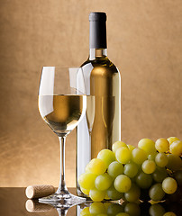 Image showing A bottle of white wine, glass and grapes