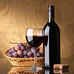 Image showing A bottle of red wine, glass and grapes