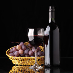 Image showing A bottle of red wine, glass and grapes