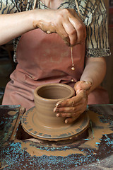 Image showing Potter creates a pitcher on a pottery wheel