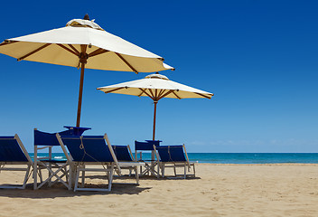 Image showing Deck chairs under an umbrella in the sand