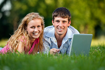 Image showing A couple relaxing in the park with a laptop