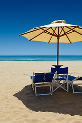 Image showing Deck chairs under an umbrella in the sand