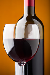 Image showing A bottle of red wine and a wine glass closeup