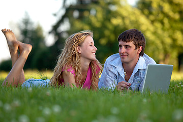 Image showing A couple relaxing in the park with a laptop