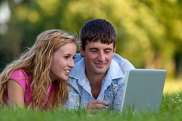 Image showing A couple relaxing in the park with a laptop