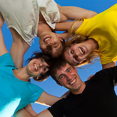 Image showing Below view of joyful teens embracing and looking at camera with 