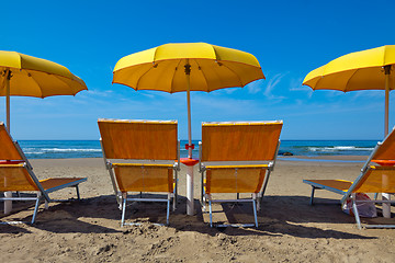 Image showing Lounge chairs under a yellow umbrella