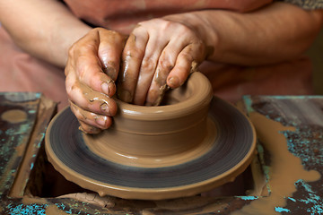 Image showing Potter creates a pitcher on a pottery wheel