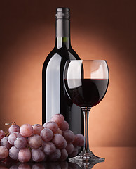 Image showing A bottle of red wine, glass and grapes