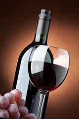 Image showing A bottle of red wine and a wine glass closeup