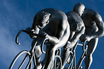 Image showing Three cyclists rides  in a downhill