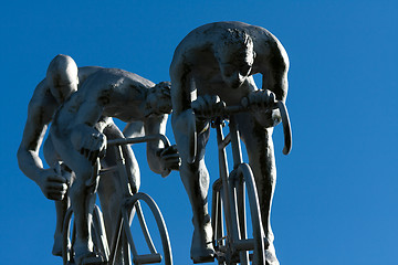 Image showing Three cyclists in a downhill