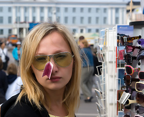 Image showing The girl tries on sun glasses