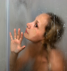 Image showing A girl is in a shower cubicle.