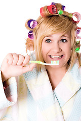 Image showing funny housewife with curlers and toothbrush