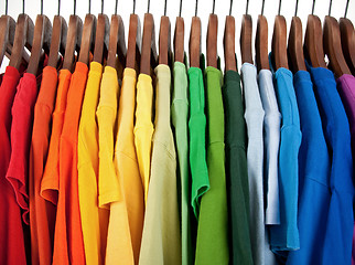 Image showing Colors of rainbow, clothes on wooden hangers