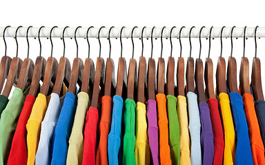 Image showing Multicolored clothes on wooden hangers