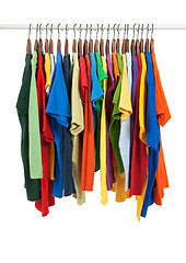 Image showing Variety of multicolored shirts on wooden hangers