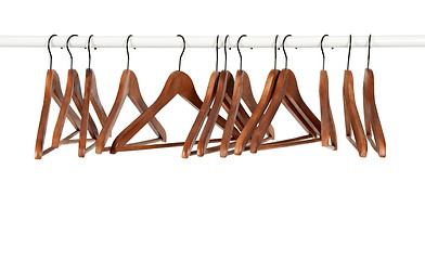 Image showing Many wooden hangers on a rod