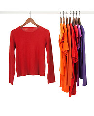 Image showing Red and purple shirts on wooden hangers