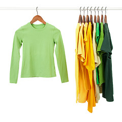 Image showing Green and yellow shirts on wooden hangers