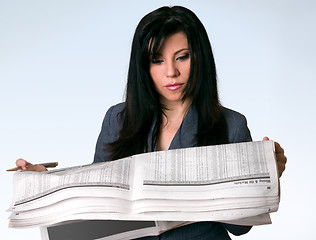 Image showing Businesswoman reading newspaper