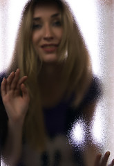 Image showing Girl behind the glass  door  