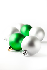 Image showing Green and silver Christmas baubles on white