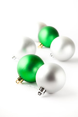 Image showing Green and silver Christmas baubles on white