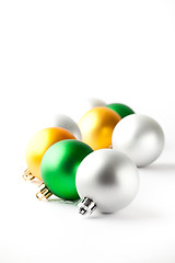 Image showing Green, gold and silver Christmas baubles on white