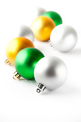 Image showing Green, gold and silver Christmas baubles on white