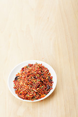 Image showing Saucer with spice mixture for rice courses on wood