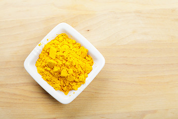 Image showing Saffron spice in white dish on wooden board