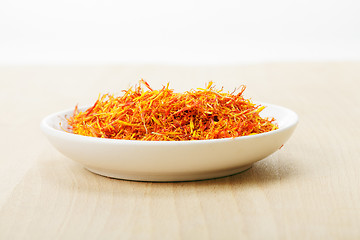 Image showing Saffron leaves spice in dish on wood