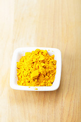 Image showing Grounded saffron spice in white dish on wood