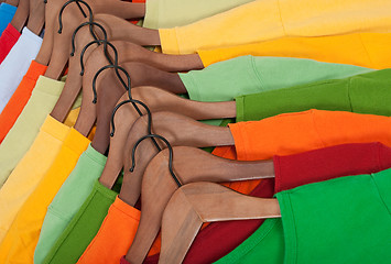 Image showing Choice of colorful t-shirts on wooden hangers