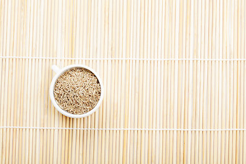 Image showing Caraway spice seeds in cup on mat