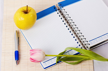 Image showing Open notebook, yellow apple and pencil 